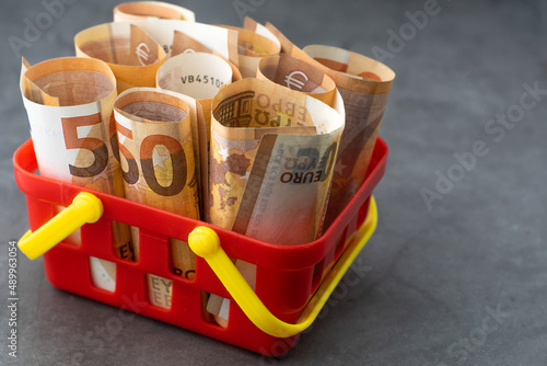 Obraz na płótnie Supermarket basket or shopping cart full of money - 50 euro banknotes. Concept of changing exchange rates of the European currency. w salonie