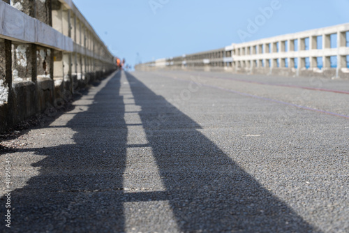 Leading lines of railings and shadows of long wharf