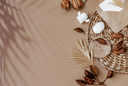 Minimal aesthetic background with envelope and dry floral branch on beige background. Wedding invitation template. Flat lay, top view, mock up, copy space .