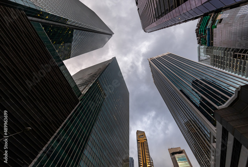 Glass Facades of skyscrapers of the financial district of Singapore on a cloudy evening, bottom view, wide lens, city center, building of large companies without logos