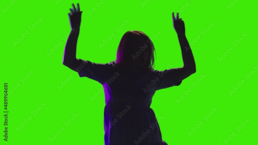 An adult girl dancing with her hands raised in slowmotion on greenscreen An adult girl dancing with her hands raised in slowmotion on greenscreen