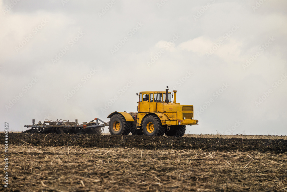Wheeled tractor pulls the disc harrow Wheeled tractor pulls the disc harrow