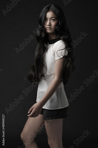 Lovely lady. Studio shot of a beautiful young woman posing against a black background. © Sanne B/peopleimages.com