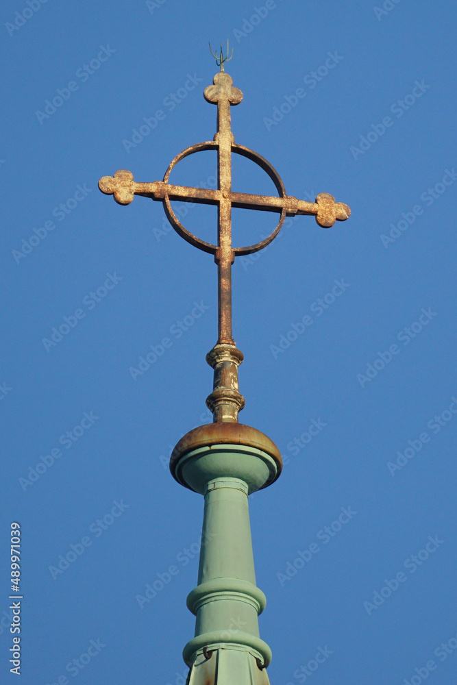 Cross with a circle on top of the church on the blue sky backgroung