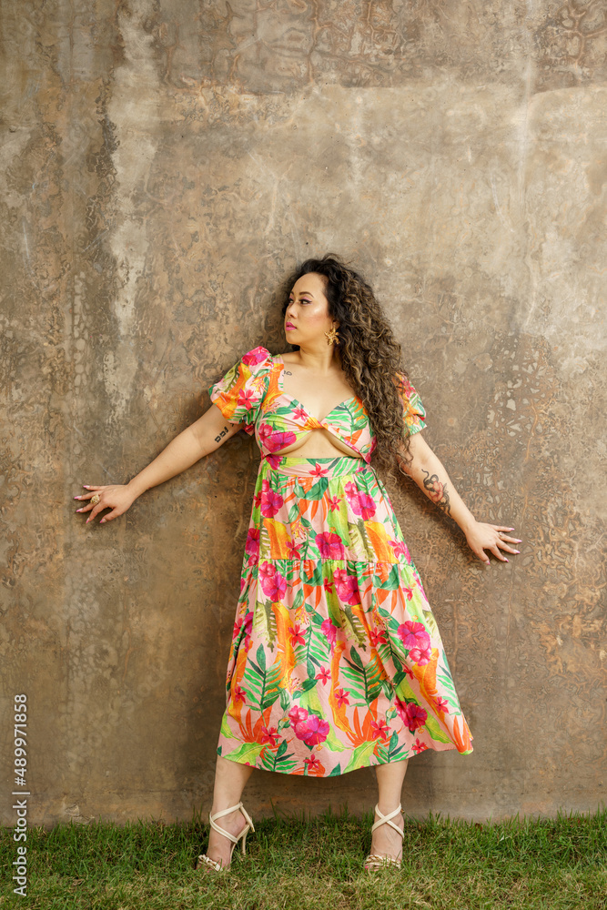 Fototapeta premium She is posing on a grunge concrete wall background