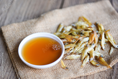 Photography fish sauce on white bowl and small dried fish on sack, fish sauce obtained from