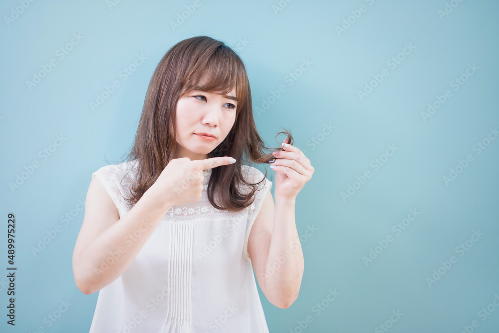 毛先を指さす女性
毛先を指さす女性