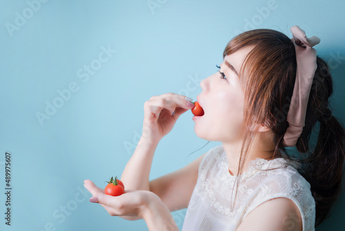 トマトを食べる女性
