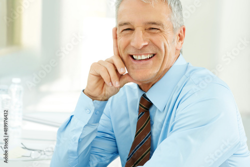 Canvas Print Cheerful senior businessman in an office environment