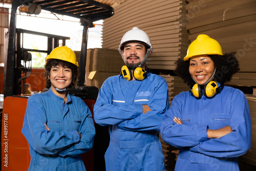 Engineer asian and african woman wearing safety take note on the paper in the automotive part warehouse.Products and corrugated cardboard. Factory for the manufacture and processing of paper.