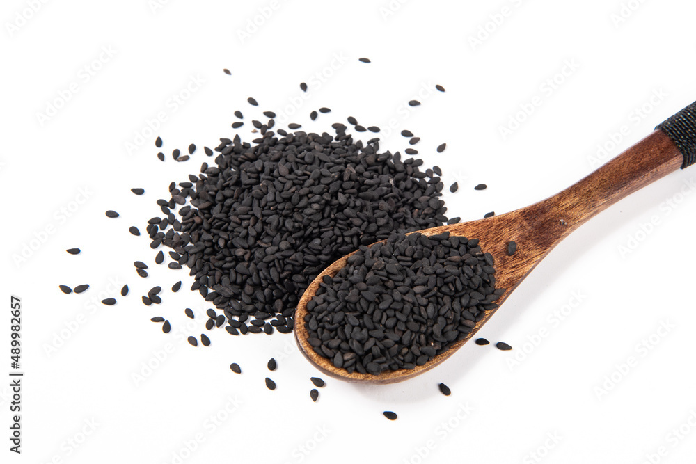 black sesame seeds in spoon on white background black sesame seeds in spoon on white background