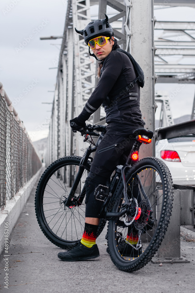 Fototapeta premium Cyclist with professional equipment riding a bike in the street