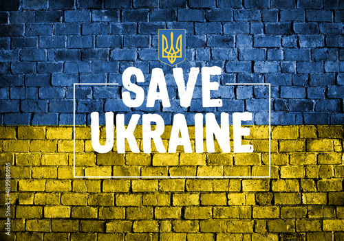 save Ukraine lettering with the national emblem of Ukraine over brick textured wall