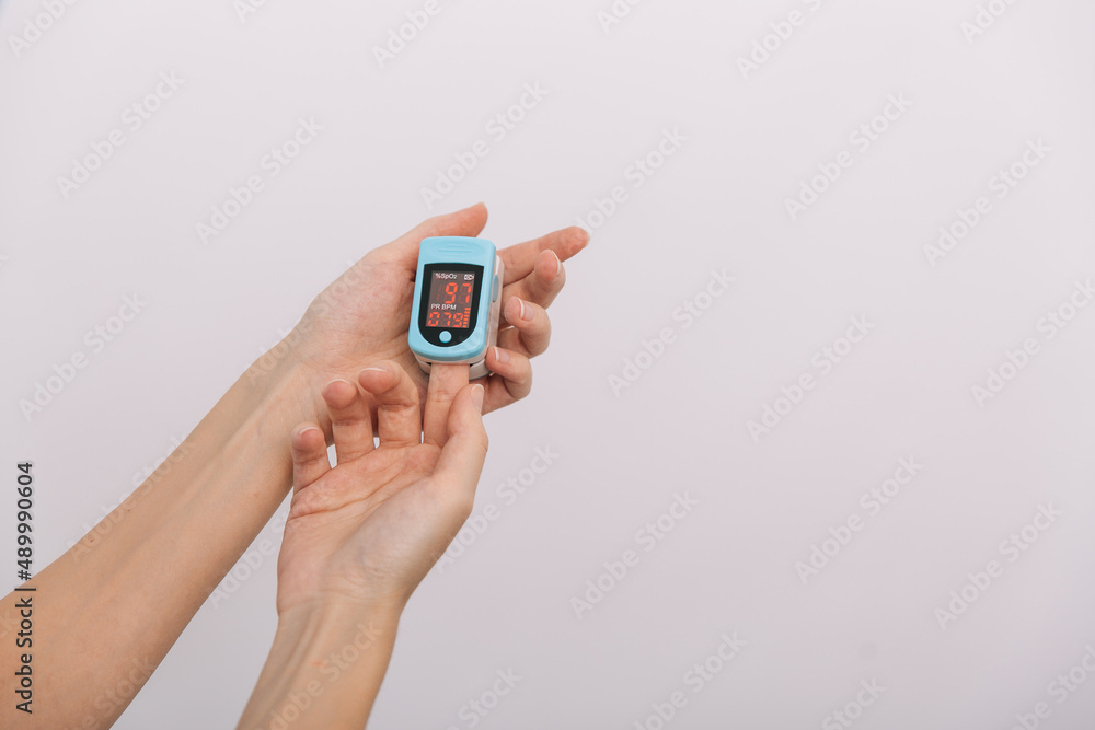 Pulse oximeter with hand of doctor isolated on white. Measuring oxygen saturation, pulse rate and oxygen levels. The concept of portable digital device to measure person's oxygen saturation. Pulse oximeter with hand of doctor isolated on white. Measuring oxygen saturation, pulse rate and oxygen levels. The concept of portable digital device to measure person's oxygen saturation.