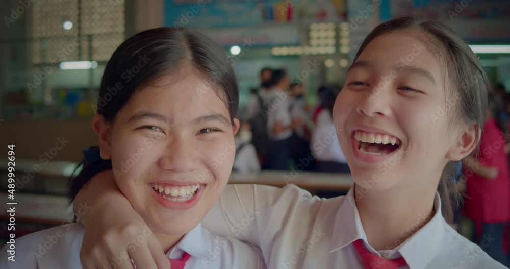 Slow motion scene of two happy smiling and laughing Asian high school student girls. Slow motion scene of two happy smiling and laughing Asian high school student girls.