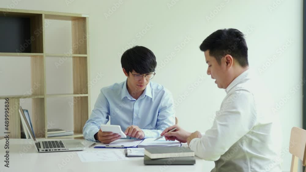 Two businessmen shaking hands as they agree on the company's budget. Two businessmen shaking hands as they agree on the company's budget.