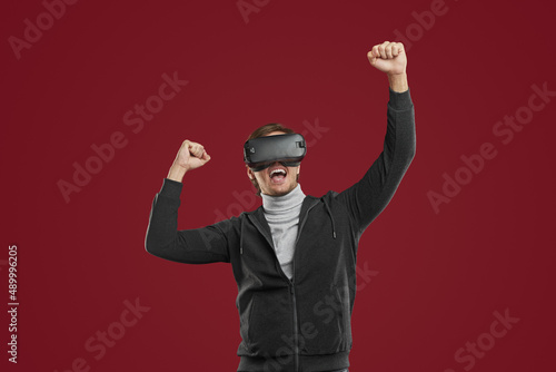 Positive man in VR glasses celebrating victory