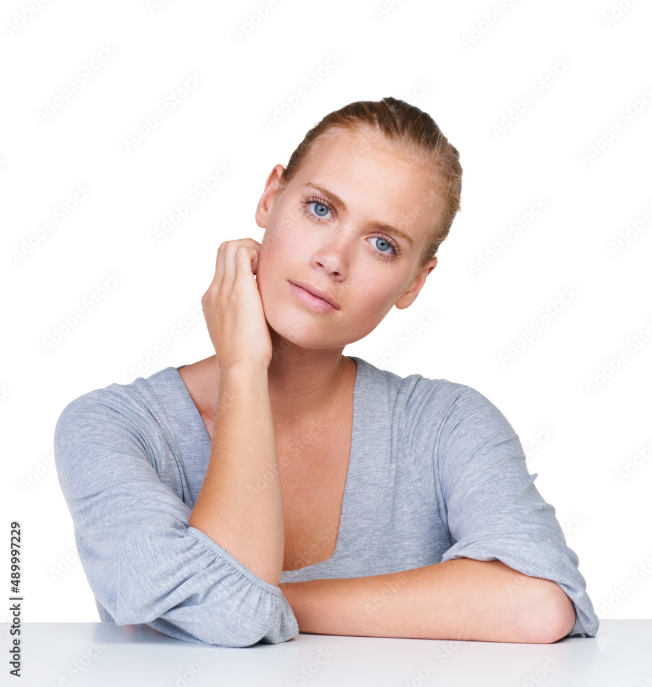 Shes got a confident stare. Portrait of an attractive young woman sitting against a white background. Shes got a confident stare. Portrait of an attractive young woman sitting against a white background.