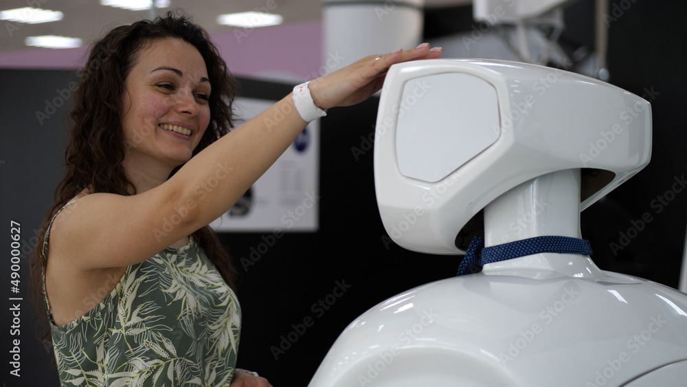 A cyborg and a young woman are cooperating each other. Woman touches a white cyborg A cyborg and a young woman are cooperating each other. Woman touches a white cyborg