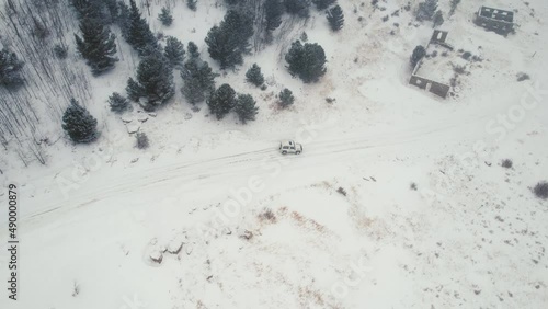 Drone Aerial View of Land Rover Defender D90 SUV Parked on Snowy Backcountry Alpine Forest Road in Rocky Mountains near Nederland Boulder Colorado USA During Heavy Snowfall. photo