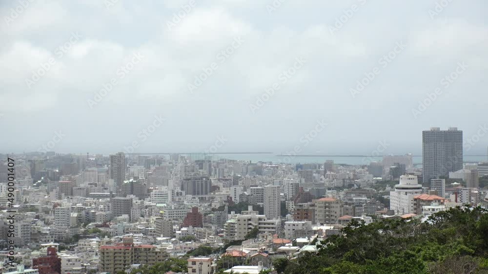 NAHA, OKINAWA, JAPAN - AUGUST 2021 : Aerial high angle wide view of Naha city in daytime. Cityscape of downtown area and sunny blue sky. Summer holiday, vacation and travel concept video. NAHA, OKINAWA, JAPAN - AUGUST 2021 : Aerial high angle wide view of Naha city in daytime. Cityscape of downtown area and sunny blue sky. Summer holiday, vacation and travel concept video.
