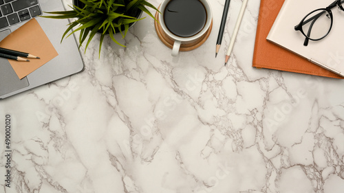 Office desk with office supplies and copy space on marble background.