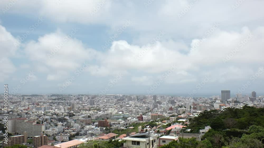 NAHA, OKINAWA, JAPAN - AUGUST 2021 : Aerial high angle view of Naha city. Cityscape of downtown area and sunny blue sky. Time lapse shot in daytime. Summer holiday, vacation and travel concept video. NAHA, OKINAWA, JAPAN - AUGUST 2021 : Aerial high angle view of Naha city. Cityscape of downtown area and sunny blue sky. Time lapse shot in daytime. Summer holiday, vacation and travel concept video.