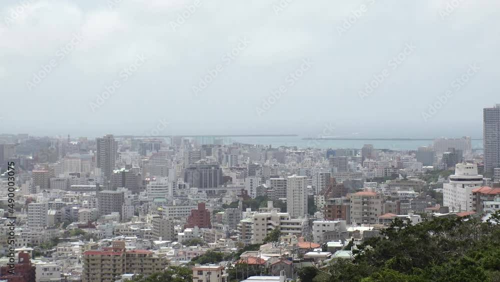 NAHA, OKINAWA, JAPAN - AUGUST 2021 : Aerial high angle view of Naha city. Cityscape of downtown area and sunny blue sky. Time lapse shot in daytime. Summer holiday, vacation and travel concept video. NAHA, OKINAWA, JAPAN - AUGUST 2021 : Aerial high angle view of Naha city. Cityscape of downtown area and sunny blue sky. Time lapse shot in daytime. Summer holiday, vacation and travel concept video.
