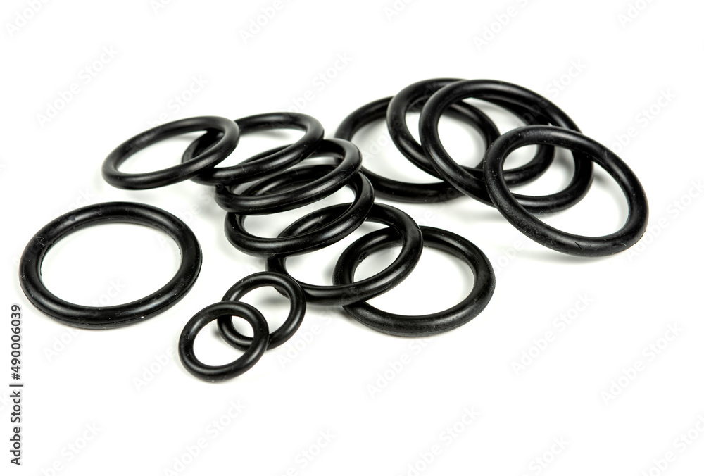 Hydraulic and pneumatic o-rings in black in different sizes on a white background. Various seals for plumbing. Sealing rings for hydraulic connections. Hydraulic and pneumatic o-rings in black in different sizes on a white background. Various seals for plumbing. Sealing rings for hydraulic connections.