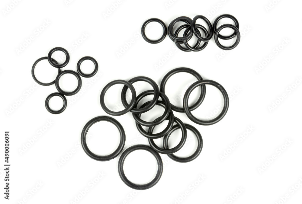 Hydraulic and pneumatic o-rings in black in different sizes on a white background. Various seals for plumbing. Sealing rings for hydraulic connections. Hydraulic and pneumatic o-rings in black in different sizes on a white background. Various seals for plumbing. Sealing rings for hydraulic connections.