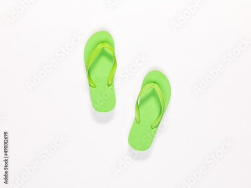 Closeup top view studio isolated shot pair of fashionable beautiful bright green casual comfortable unisex rubber material slipper, flip flop, sandal, footwear on white background with copy space