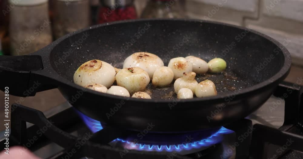 Shallots are fried in pan on gas stove Shallots are fried in pan on gas stove