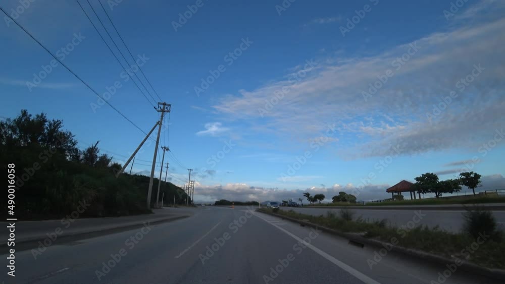 OKINAWA, JAPAN - AUGUST 2021 : Driving shot of Okinawa in sunset time. Point of view (POV), seaside road drive. Summer holiday, vacation and travel concept video. OKINAWA, JAPAN - AUGUST 2021 : Driving shot of Okinawa in sunset time. Point of view (POV), seaside road drive. Summer holiday, vacation and travel concept video.