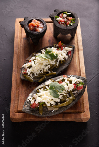 Tlacoyos and Nopales. Mexican pre hispanic dish made of blue corn flour patty filled with refried beans. Popular street food in Mexico.