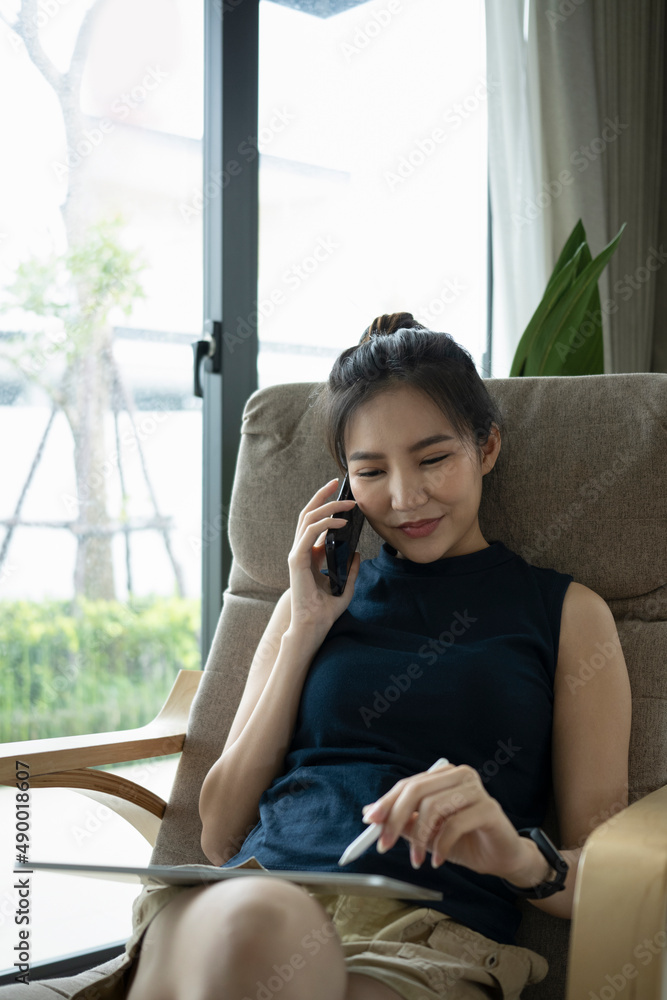 Attractive young woman using digital tablet and talking on mobile phone at home. Attractive young woman using digital tablet and talking on mobile phone at home.