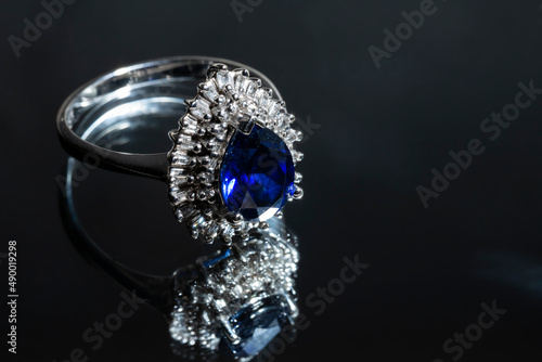 jewelry ring witht big blue sapphir on black coal background photo