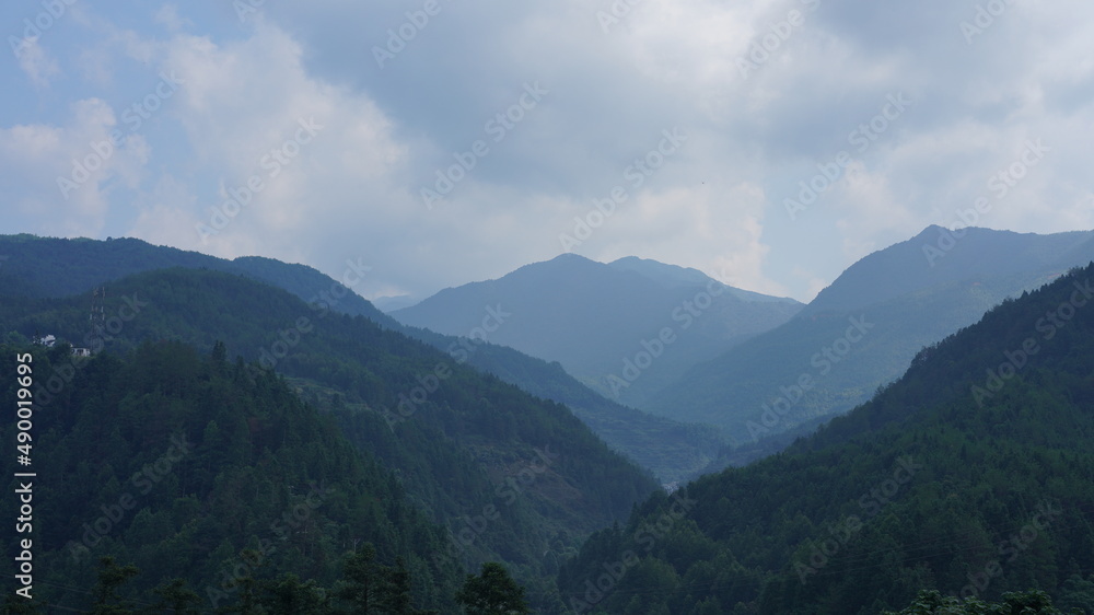 Naklejka premium The beautiful mountains landscapes with the green forest and little village as background in the countryside of the China