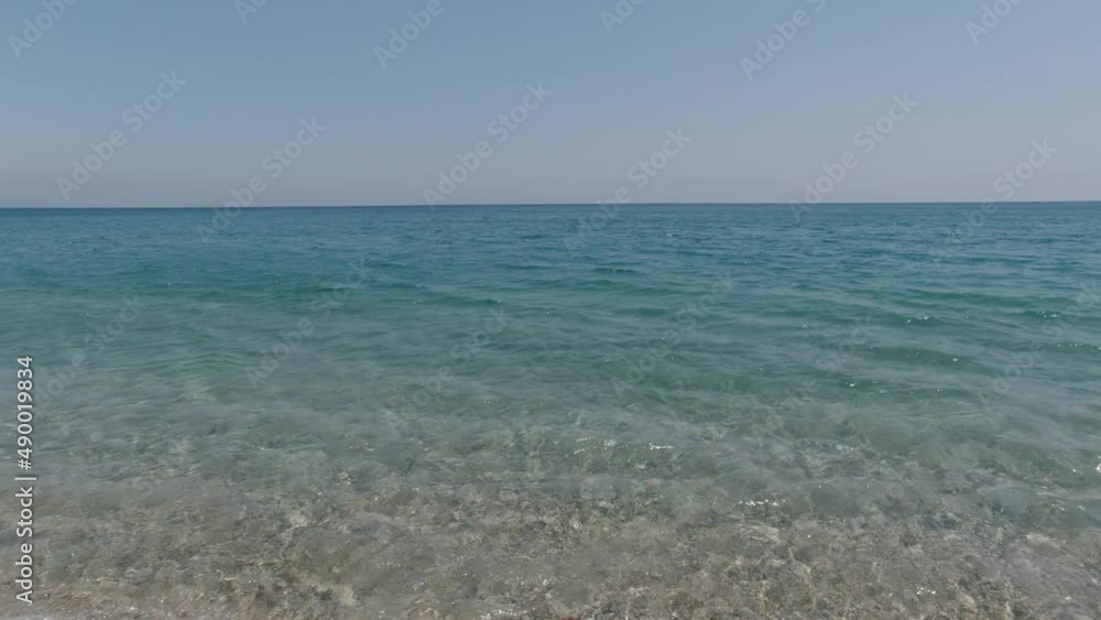 Calm sea. Turquoise clear water of sea and pebbles on the beach. Traveling or vacation or summer or holiday background 4k video. Calm sea. Turquoise clear water of sea and pebbles on the beach. Traveling or vacation or summer or holiday background 4k video.