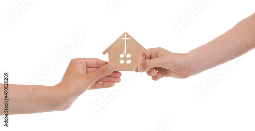 Hands of family with wooden figure of church on white background. Concept of Christianity