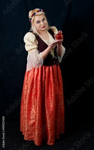 Ukrainian pretty woman holding apple on  black background © Konstantyn