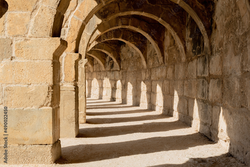 Light and shadow in ancient building with many arches in it