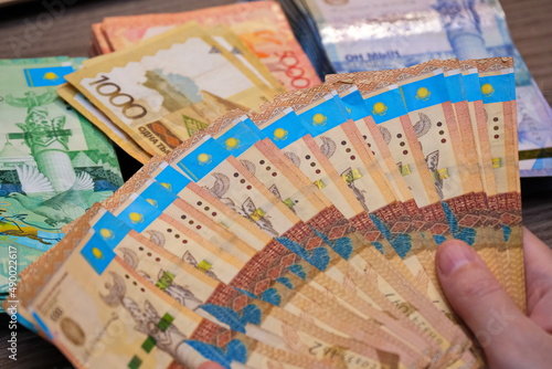 Almaty, Kazakhstan - 12.01.2020 : Kazakhstani tenge banknotes are arranged in a fan in the hands.