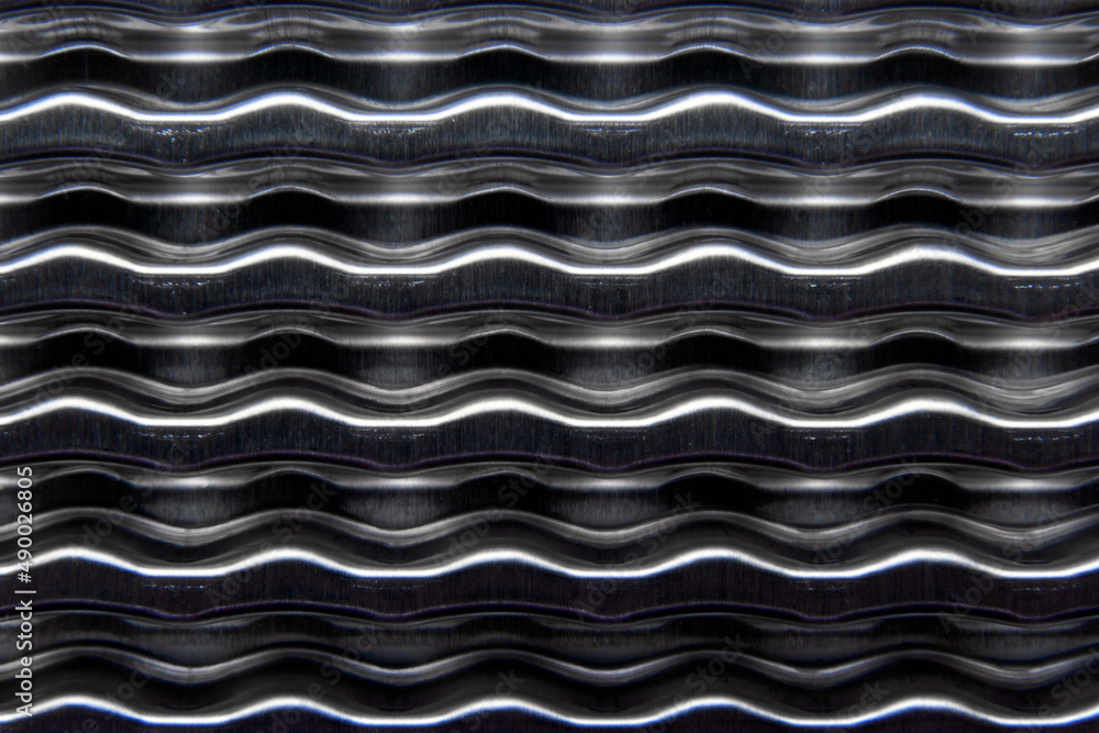 shiny metallic waves of bent metal. aluminum stamping in production shiny metallic waves of bent metal. aluminum stamping in production