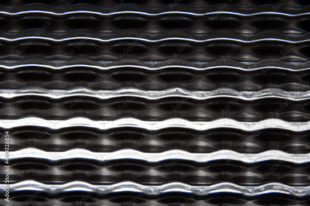 shiny metallic waves of bent metal. aluminum stamping in production shiny metallic waves of bent metal. aluminum stamping in production
