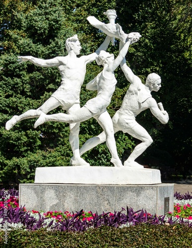 Photography Rostov-on-Don, Russia - September 12, 2019: White sculpture of Olympians in middle of huge flower bed on the embankment of Don River in city Rostov-on-Don