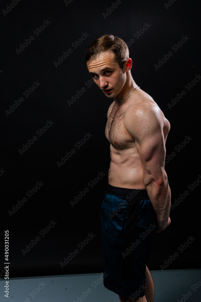 Man on black background keeps dumbbells pumped up in fitness active biceps black, body training workout hold dumbbell, healthy weightlifting. skin Man on black background keeps dumbbells pumped up in fitness active biceps black, body training workout hold dumbbell, healthy weightlifting. skin