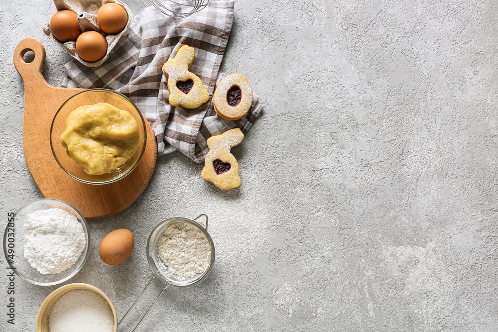 Bowl with dough and ingredients for preparing Easter cookies on grey background Bowl with dough and ingredients for preparing Easter cookies on grey background