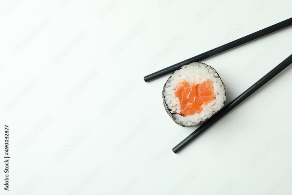 Chopsticks with maki on white background, space for text Chopsticks with maki on white background, space for text