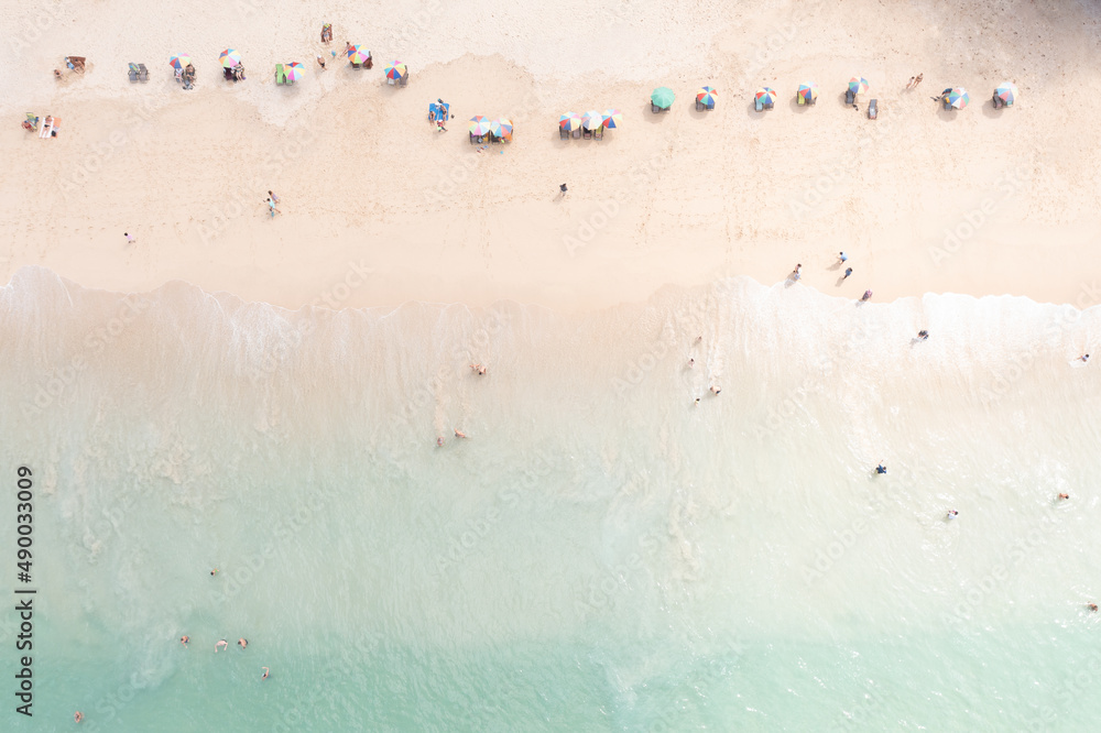 Fototapeta premium aerial top view tourist playing in the sea on vacation and umbrella on the beach, summer holiday concept