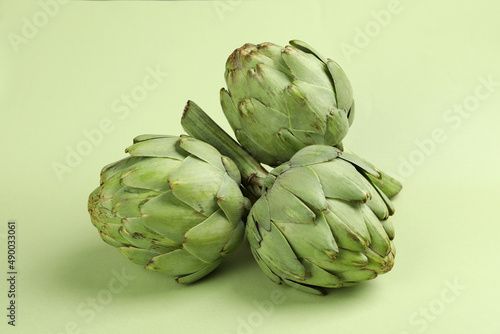 Concept of healthy food with artichoke on green background